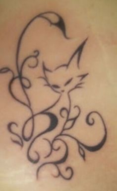 a cat tattoo on the back of a woman's upper body, with swirls and leaves