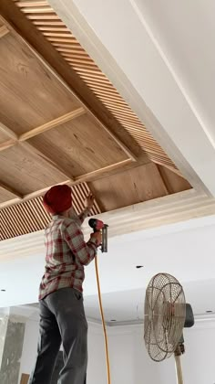 a man using a power drill to fix a ceiling fan