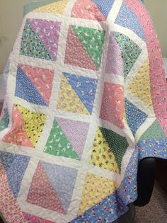 a multicolored quilt sitting on top of a chair