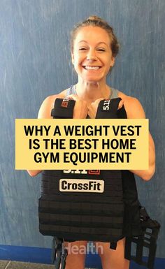 a woman holding a weight vest with the words crossfit written on it in front of her