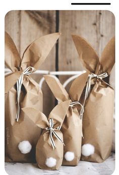 three brown paper bags with cotton balls tied to the top and two are sitting next to each other