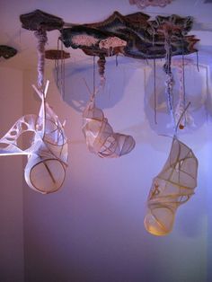 three hanging objects made out of paper on a wall