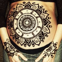 a pregnant belly with henna designs for expect mothers written on the stomach and hands