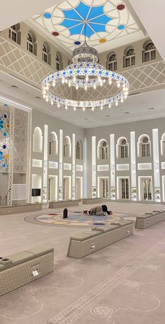 a large room with a chandelier hanging from the ceiling and several benches in front of it