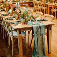 a long table is set with green linens and place settings for an elegant dinner