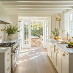 an open kitchen with white cabinets and wood flooring is pictured in this image from the front door