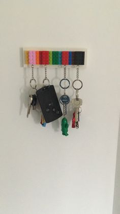 several key chains hanging on the wall with keys attached to them, and a car key holder