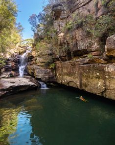 a person in a kayak near a waterfall