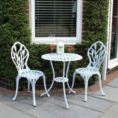 two chairs and a table outside near a window