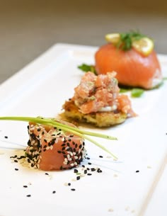 three different types of food are on a white plate with sprinkled black sesame seeds