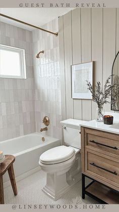 a white toilet sitting next to a bath tub in a bathroom under a mirror and wooden cabinets