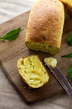 a loaf of bread sitting on top of a wooden cutting board next to a knife