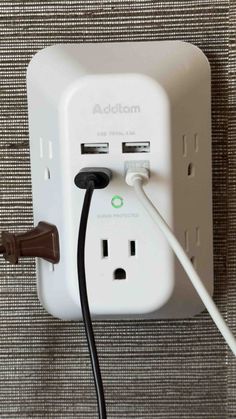 an electrical outlet is plugged in to a wall charger with two wires attached