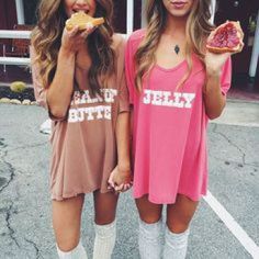 two women standing next to each other holding donuts