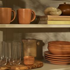 the shelves are filled with dishes and cups