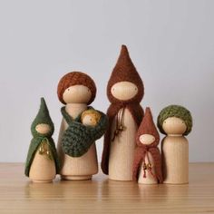 a group of wooden dolls standing next to each other on top of a wood table