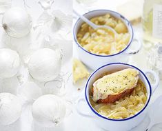 two bowls filled with food next to onions and garlic on a white tablecloth covered table