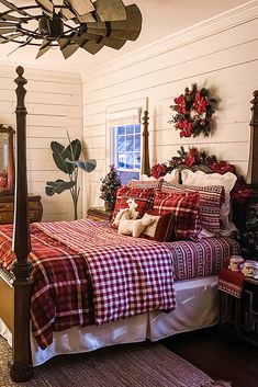 a bedroom decorated for christmas with red and white plaid bedding