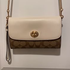 New Coach Crossbody, Twist Lock With Detachable Wristband. Two Tone -White Flap Over Brown Classic Logo. Slip Pocket On The Exterior, 8 Card Slots, And Zipper Compartment Inside. Approx. Dimension 8in X 5in Gold Tone Chain Drop Approximately 22in. Coach Everyday Bag With Gold-tone Hardware, Classic Coach Bags With Gold-tone Hardware, Coach Gold Bags With Gold-tone Hardware, Coach Bags With Gold-tone Hardware, Brown Coach Bags With Silver-tone Hardware, Coach 1941, Coach Crossbody, Coach Crossbody Bag, City Bag