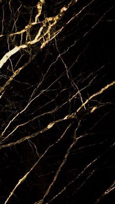 a black and gold marble textured wallpaper with light streaks on it's edges