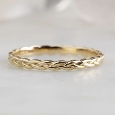 The Gold Braided Stacking Ring in 14K Yellow Gold on White Marble Tile Hammered Gold Wedding Band, Rope Wedding Band, Braided Wedding Band, Alexis Russell, Delicate Wedding Band, Textured Wedding Band, Watermelon Tourmaline Ring, Stackable Wedding Bands, Gold Statement Ring