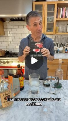 a man standing in front of a kitchen counter holding up a card with the words, that freezer door cocktails are cocktails