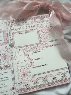 a pink and white wedding album with pearls on the edge, ribbon tied around it