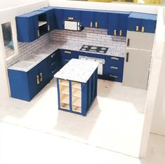 a model kitchen with blue cabinets and white counter tops