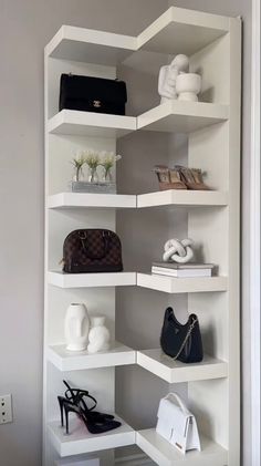 a white shelving unit with purses and handbags on it's shelves