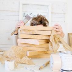 a woman sitting at a table with lots of crafting supplies on top of it