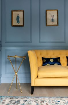 a yellow chair sitting next to a table on top of a hard wood floor covered in blue paint