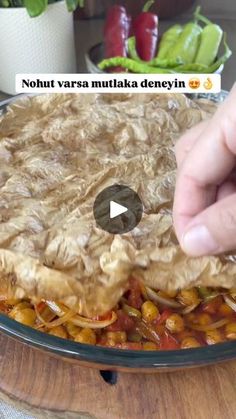 a person is placing food on top of a plate with vegetables in the back ground