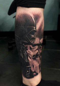 a man's leg with a black and grey tattoo on it, depicting darth vader