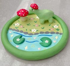 a green toy with two mushrooms on top of it