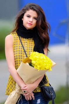 a woman holding a bouquet of yellow flowers