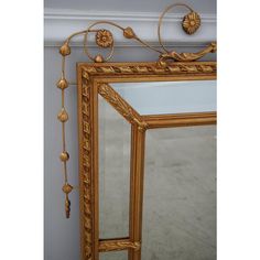 an ornate gold framed mirror hanging on the wall