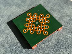 a green and orange box sitting on top of a blue cloth covered ground with white dots