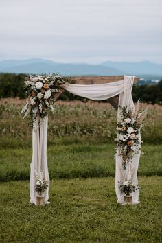 an outdoor ceremony setup with flowers and greenery