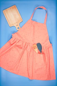 an apron sewing pattern is shown with a cutting board and knife in the back pocket