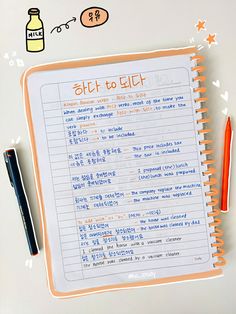 an open notebook with writing on it next to a pen and orange highlighters in the background