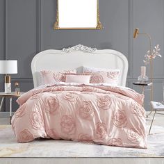 a bed with pink comforters and pillows in a room