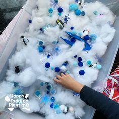 a child is playing with cotton balls and snowflakes in a playroom filled with toys