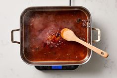 a wooden spoon in a pot filled with food