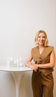 a woman standing next to a white table