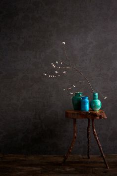 three blue vases sitting on top of a wooden table