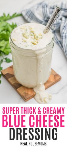 a jar filled with blue cheese dressing sitting on top of a cutting board next to parsley