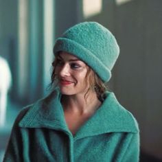 a woman wearing a green coat and hat