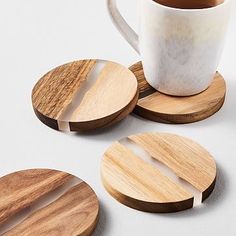 three wooden coasters and a coffee cup on a table