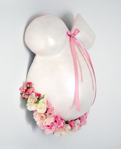 a large balloon shaped like a pregnant woman with pink flowers around the neck and breast