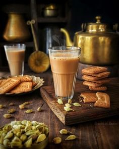 there is a cup of coffee next to some crackers and nuts on the table